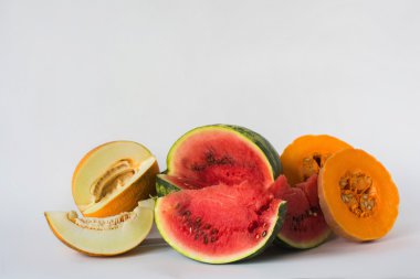 Kavun, karpuz ve beyaz bir arka plan üzerine dilimlenmiş kabak