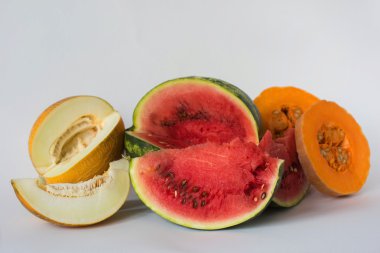 Kavun, karpuz ve beyaz bir arka plan üzerine dilimlenmiş kabak