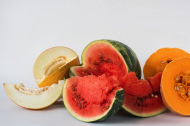 Kavun, karpuz ve beyaz bir arka plan üzerine dilimlenmiş kabak