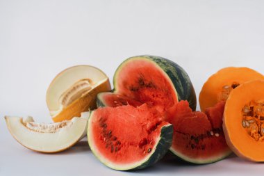 Kavun, karpuz ve beyaz bir arka plan üzerine dilimlenmiş kabak