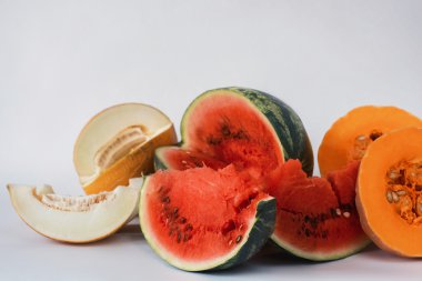 Kavun, karpuz ve beyaz bir arka plan üzerine dilimlenmiş kabak