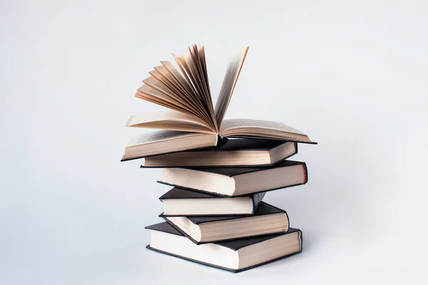 Beyaz bir arka plan üzerinde yalan kitap yığını