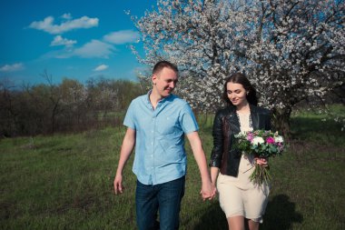 Mavi gökyüzü arka plan üzerinde elinde Çiçek Bahçe tutmak içinde çalışan mutlu çift el