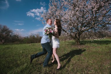 Güzel genç çift dans ve mavi gökyüzü arka plan üzerinde having fun