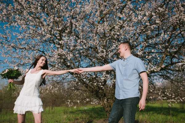 Hermosa pareja joven bailando y divirtiéndose en el fondo del cielo azul — Foto de Stock