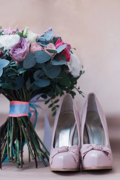 Belos sapatos de casamento com saltos altos e um buquê de flores coloridas — Fotografia de Stock