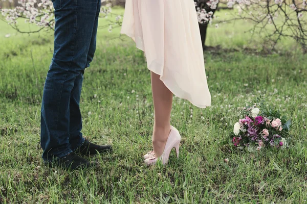 Krásné nohy mladé dívky na vysokých podpatcích vedle nohy člověka — Stock fotografie