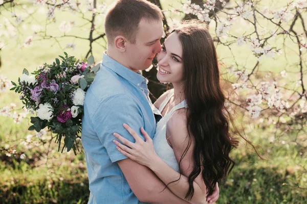 Sensual al aire libre retrato de joven elegante pareja de moda posando en primavera cerca de árbol de flores —  Fotos de Stock