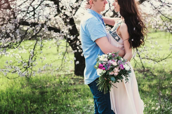Sensual al aire libre retrato de joven elegante pareja de moda posando en primavera cerca de árbol de flores —  Fotos de Stock