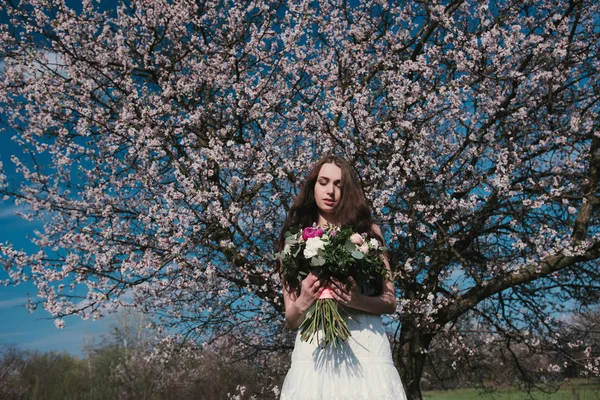 Mulher em árvores florescentes — Fotografia de Stock