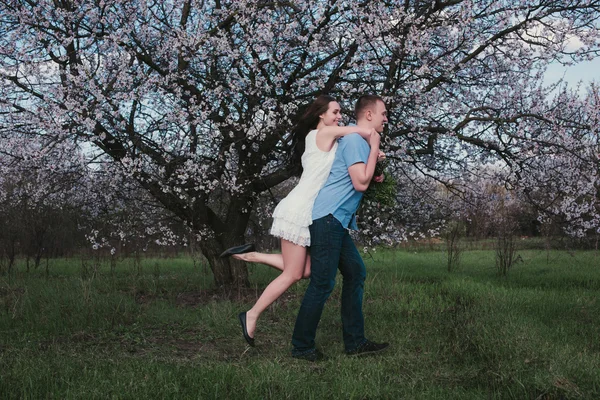 Beautiful young couple dancing and having fun on blue sky background — Stock Photo, Image