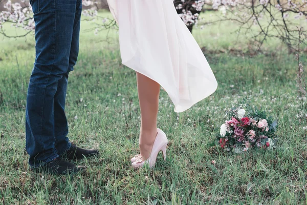 Beautiful legs of young girl in high heels next to the legs Man — Stock Photo, Image