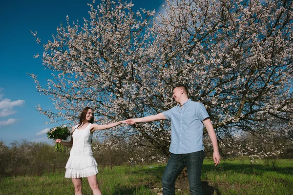 Красивая молодая пара танцует и веселится на голубом фоне неба — стоковое фото