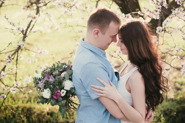 Sensuell utomhus porträtt av unga snygga mode par poserar på våren nära Blossom Tree — Stockfoto