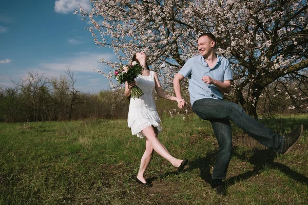 Belo jovem casal dançando e se divertindo no fundo do céu azul — Fotografia de Stock