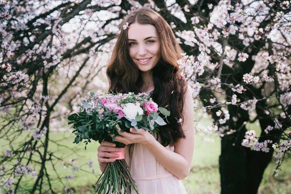 Жінка в квітучих деревах. Жінка з весільним букетом в руках . — стокове фото