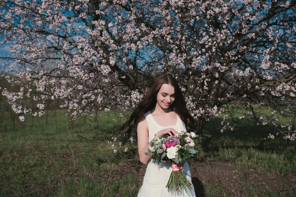 Woman in blooming trees — Stock Photo, Image