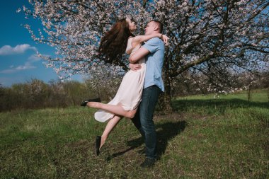 Güzel genç çift dans ve mavi gökyüzü arka plan üzerinde having fun