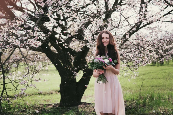 Жінка в квітучих деревах. Жінка з весільним букетом в руках . — стокове фото