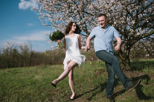 Красивая молодая пара танцует и веселится на голубом фоне неба — стоковое фото