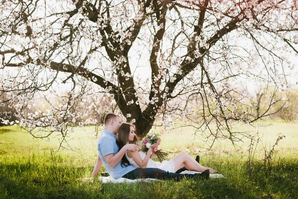 Young couple sitting in spring nature close-up portrait — Stockfoto