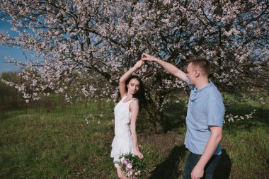 Güzel genç çift dans ve mavi gökyüzü arka plan üzerinde having fun