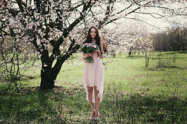 Mujer en árboles florecientes. Mujer con ramo de bodas en las manos . —  Fotos de Stock