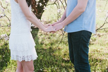 Eller genç erkek ve kadın güzel bir kız bloom bahçede sarılma