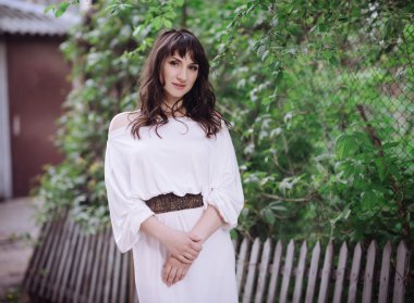 Açık havada beyaz elbiseli güzel bir esmer kadın portresi