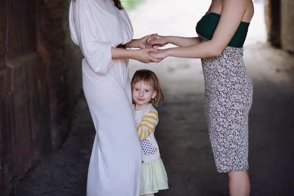 Two women holding hands with a child — Stock Photo, Image