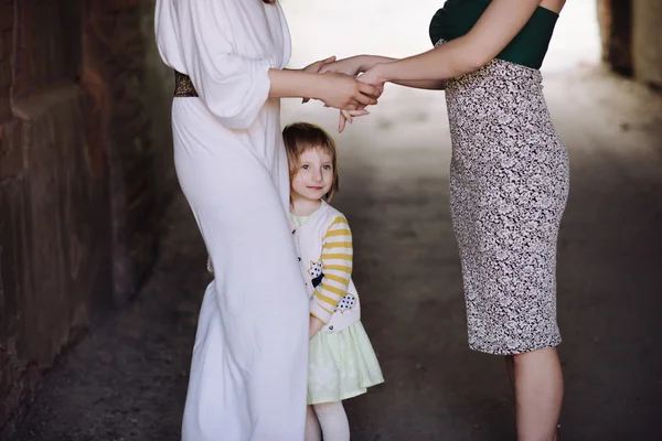 Two women holding hands with a child — Stock Photo, Image
