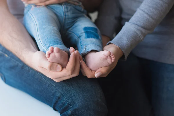 Baby fötter på far och mor händer — Stockfoto