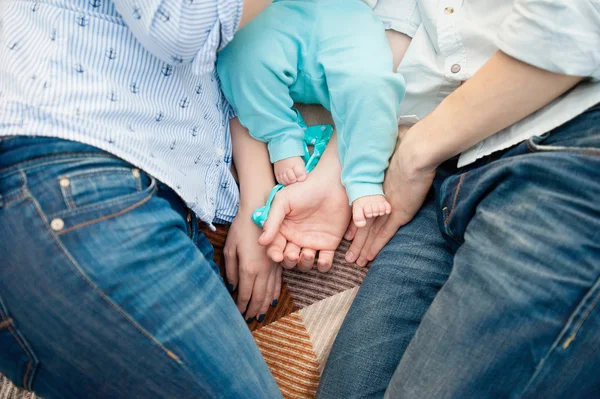 Baby fötter på far och mor händer — Stockfoto