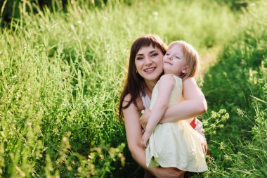 Annem öper ve kızı sunsetlight doğada hugs