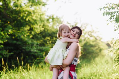 Annem öper ve kızı sunsetlight doğada hugs