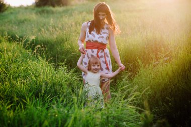 Anne ve kızı doğa günbatımı ışık birlikte dans