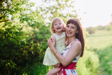 Annem öper ve kızı sunsetlight doğada hugs