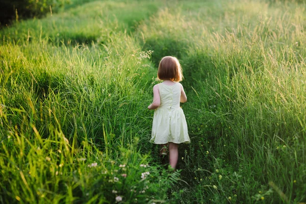 Außenporträt eines niedlichen kleinen Mädchens, das im Gras spielt — Stockfoto