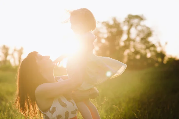 Mamá e hija bailando en la naturaleza juntas en la luz del atardecer —  Fotos de Stock