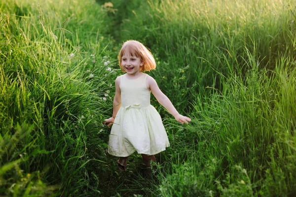 Venkovní portrét roztomilá holčička hraje v trávě — Stock fotografie