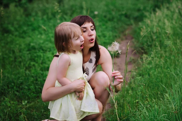 Mom kisses and hugs daughter on nature — Stock Photo, Image