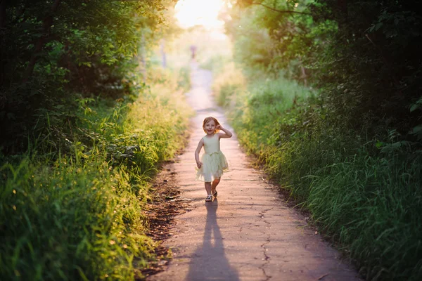 Venkovní portrét roztomilá holčička hraje v trávě — Stock fotografie