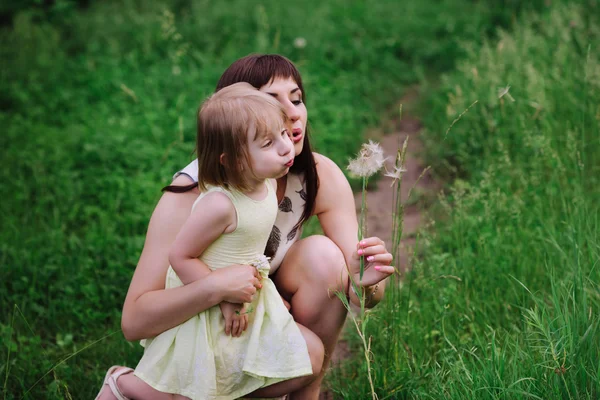 Mom kisses and hugs daughter on nature — Stock Photo, Image