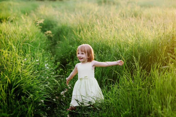 草で遊ぶかわいい女の子の屋外のポートレート — ストック写真