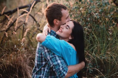 Şık güzel genç çift ayakta açık havada, günbatımı ışığı