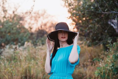 Gün batımı ışık alanında şapkalı güzel bir kız portresi