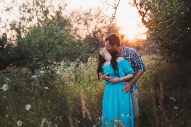 Şık güzel genç çift ayakta açık havada, günbatımı ışığı