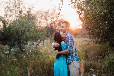 Şık güzel genç çift ayakta açık havada, günbatımı ışığı