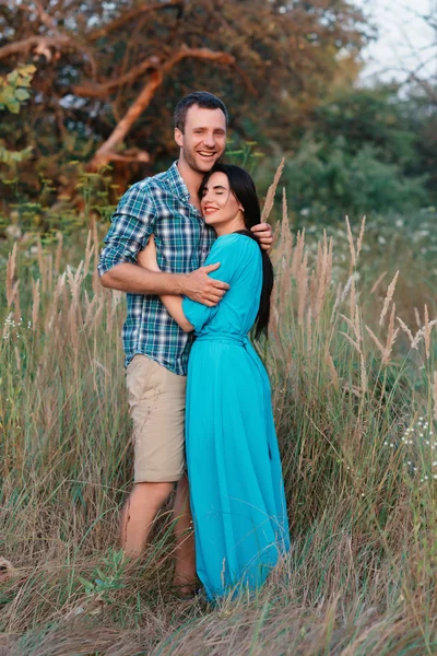 Elegante hermosa pareja joven de pie al aire libre en la luz del atardecer — Foto de Stock