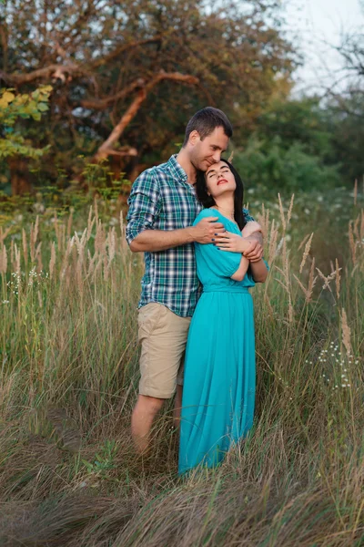 Elegante hermosa pareja joven de pie al aire libre en la luz del atardecer — Foto de Stock